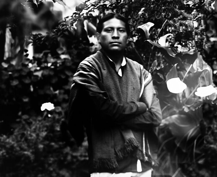 Young man posing around the flowers