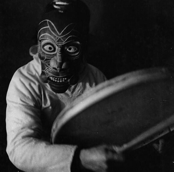 Danseur eskimo masqué, jouant du tambour de peau