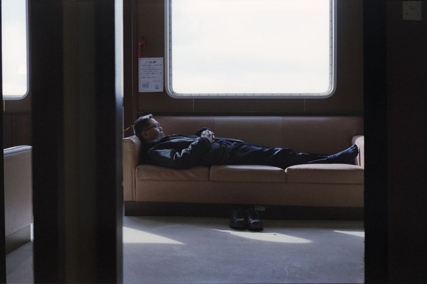 A man who looks a little like Kenzaburo sleeps, passenger ship to Hiroshima