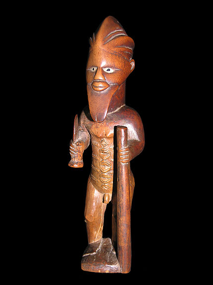 Statuette masculine debout tenant un bâton et un coutelas