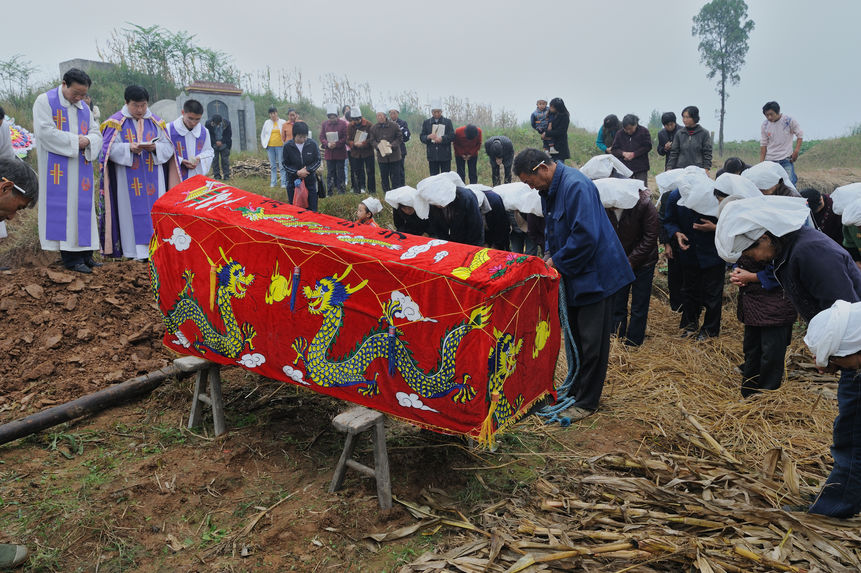 Une linceul [sic] rouge avec une paire de dragons brodés recouvre un cercueil