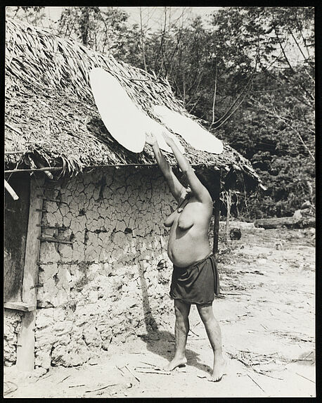 Sans titre [femme installant des galettes de casabe sur le toit d'une maison afin de les faire sécher]